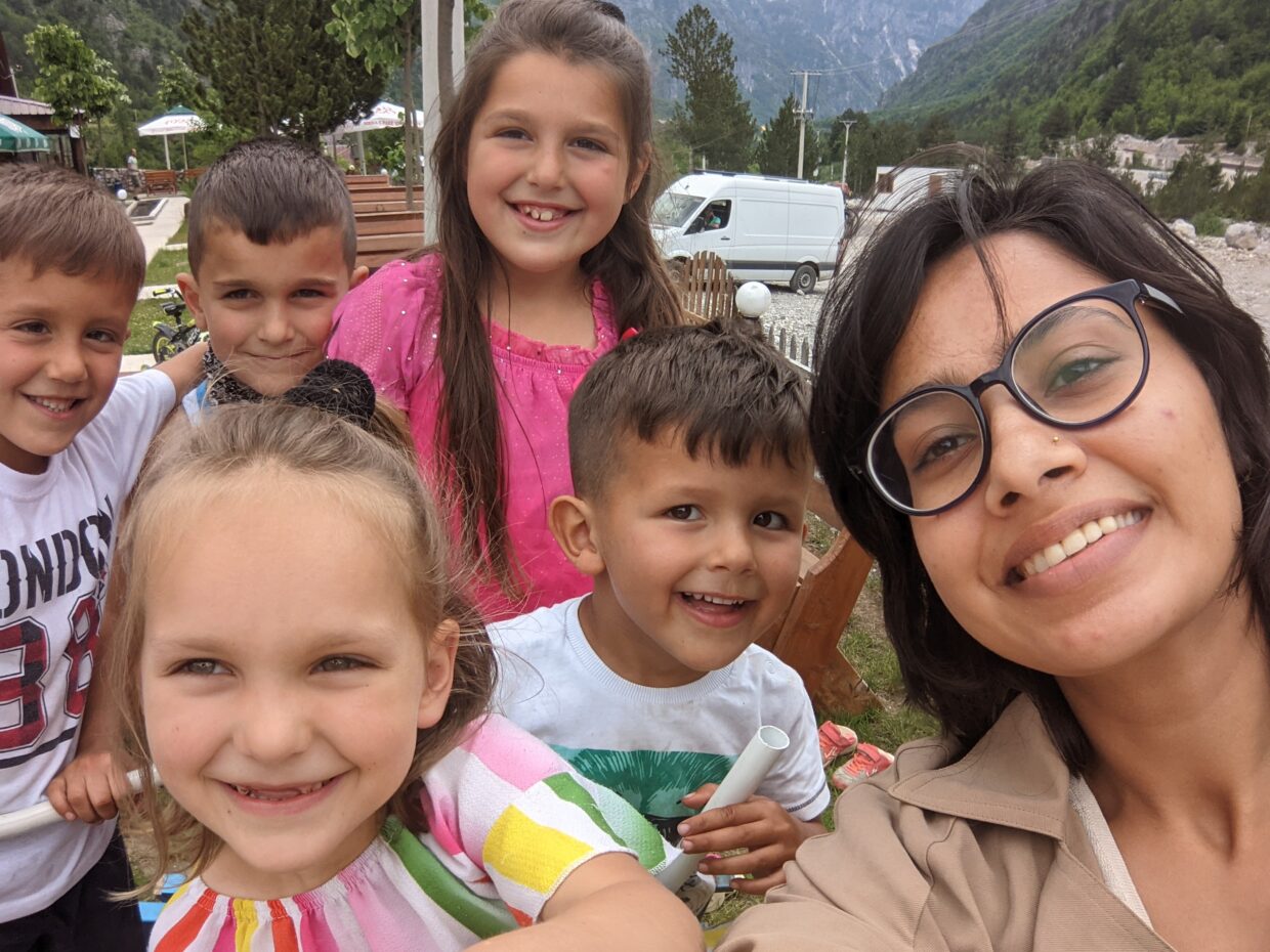 A selfie. A woman takes a photo with five small children.